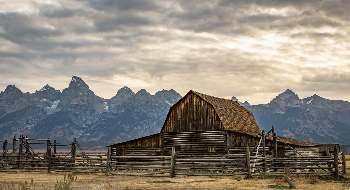 grand teton national park brown wooden barn under white sky during daytime mountain